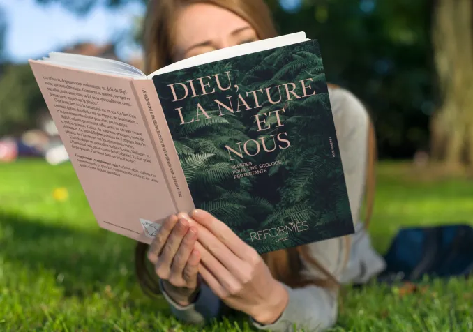 Le mook « Dieu, la nature et nous, Repères pour une écologie protestante» lu dans un pré.  Photomontage (Eh oui, notre mook est en cours de fabrication)