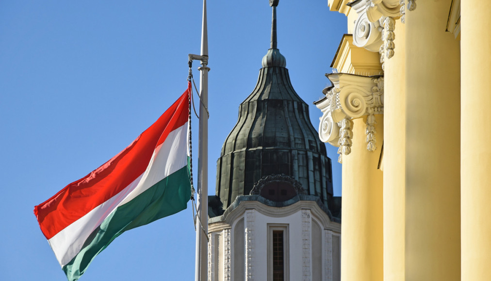 Le drapeau national hongrois à côté de l&#039;église dans la ville de Debrecen / ©iStock/majorosl